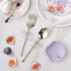 Bitossi Home Fiocco bow salad servers in silver, styled in a table setting